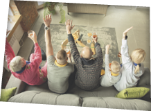Family cheering and watchin tv at home in the living room. Concept of sport, emotions, togetherness. Grandparents and parents, kids. Football or basketball, tennis, hockey, handball.